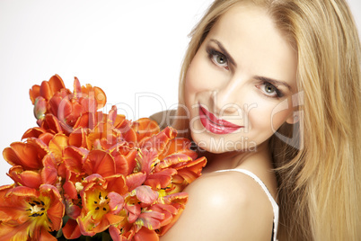 Beautiful blonde girl with the bouquet of tulips isolated on a w