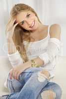 Beautiful and attractive blonde woman posing in blue jeans dress