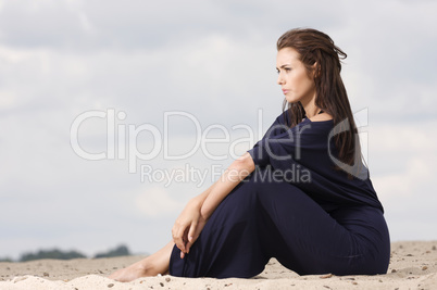 Sexy brunette posing in violet dress.