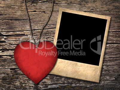 red paper heart and old photo  on the wooden background