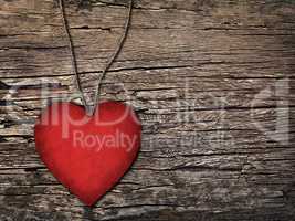 red paper heart on a string on the wooden background