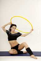 Beautiful sporty woman in black dress slim body with hula hoop