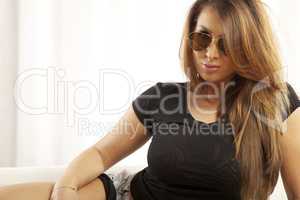 Young slim sexy woman in black shirt sweater on sofa