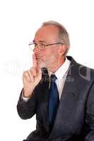 Businessman giving sign with finger over mouth.