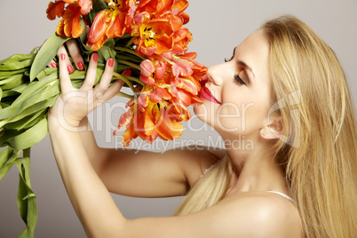 Beautiful blonde girl with the bouquet of tulips isolated on a w