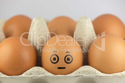 Egg with a face in a egg carton.