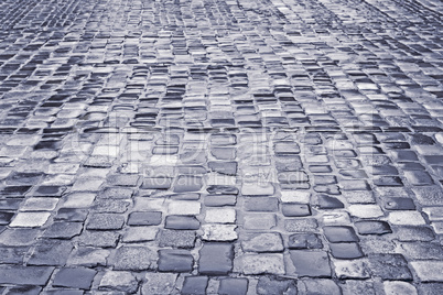 Road with wet cobblestones in rainy weather