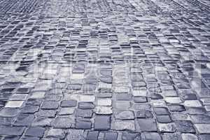 Road with wet cobblestones in rainy weather