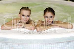 Two young beautiful girls in jacuzzi