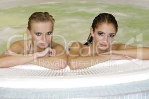 Two young beautiful girls in jacuzzi