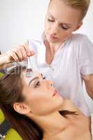 young woman getting beauty skin mask treatment on her face with