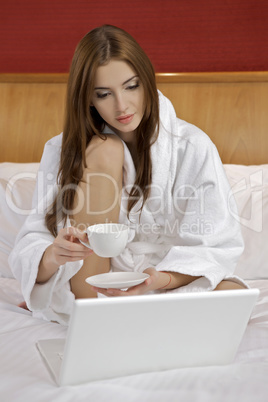 Portrait of beautiful woman with laptop on bed