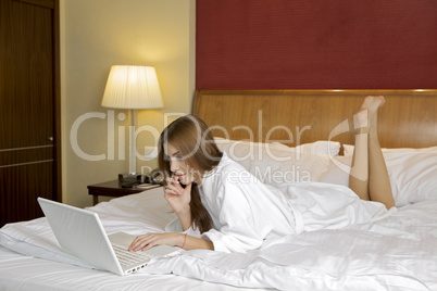 Portrait of beautiful woman with laptop on bed