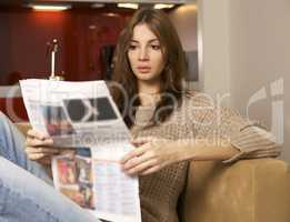mid adult woman drinking coffee and reading news