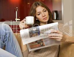 mid adult woman drinking coffee and reading news