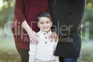 Young Mixed Race Boy Portrait Outdoors With Parents Behind
