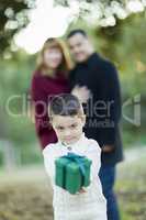 Mixed Race Boy Holding Gift In Front with Parents Behind