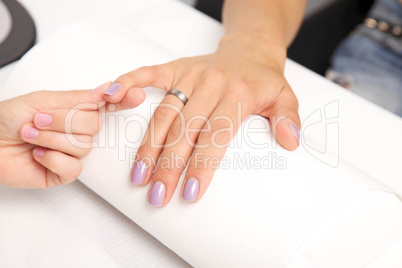 Manicure - Beautiful manicured woman's nails with violet nail po