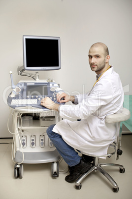 Portrait of young male technician operating ultrasound machine