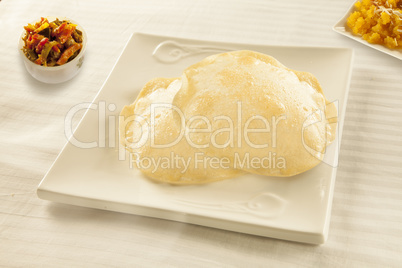 Fried flat bread puri with halwa sweet and achaar pickles