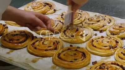german bakery spread liquid sugar on a pastery roll 11714