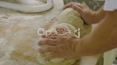 german baker kneading two breads side view 11723