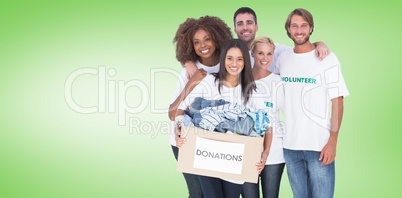 Composite image of smiling group of volunteers holding donation
