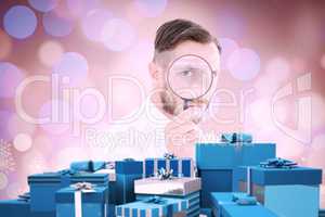 Composite image of geeky businessman looking through magnifying