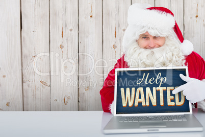 Composite image of santa using laptop