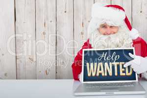 Composite image of santa using laptop