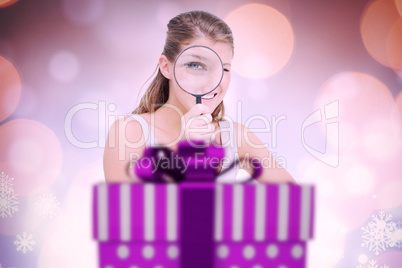 Composite image of woman looking through a magnifying glass