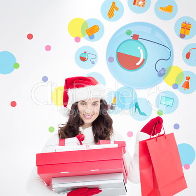 Composite image of festive brunette holding christmas gifts and