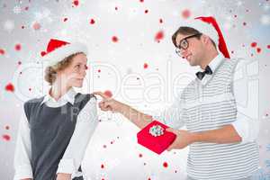 Composite image of geeky hipster offering present to his girlfri