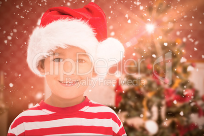 Composite image of cute little boy in santa hat