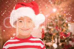 Composite image of cute little boy in santa hat