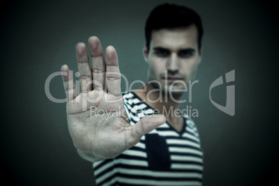 Composite image of portrait of serious man making stop sign