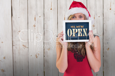 Composite image of festive blonde showing a tablet