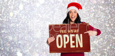 Composite image of woman pointing at white sign