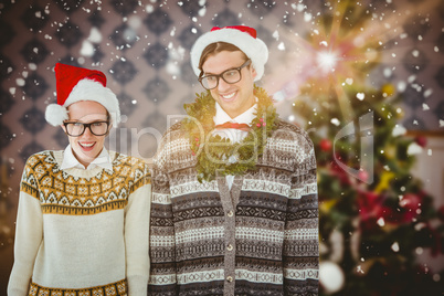 Composite image of smiling man wearing green garland by woman