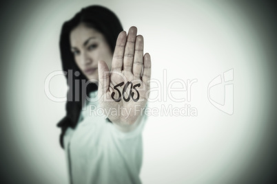 Composite image of beautiful serious woman showing her hand