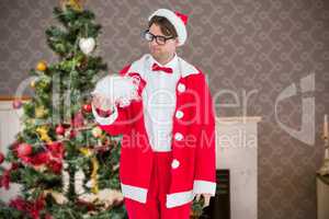 Composite image of geeky hipster in santa costume looking at bea