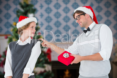 Composite image of geeky hipster offering present to his girlfri