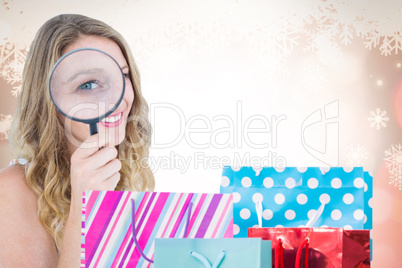 Composite image of smiling woman holding magnifying glass