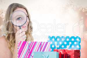 Composite image of smiling woman holding magnifying glass