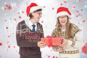 Composite image of geeky hipster couple holding present