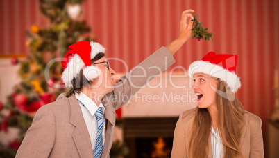 Composite image of man wearing santa hat and holding mistletoe w