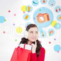 Composite image of brunette with ear muffs holding shopping bag