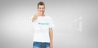 Composite image of portrait of a happy male volunteer pointing a