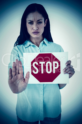 Composite image of woman showing card and saying stop