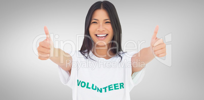 Composite image of woman wearing volunteer tshirt giving thumbs